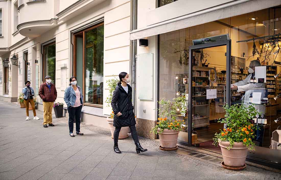 Masked shoppers entering a retail store.