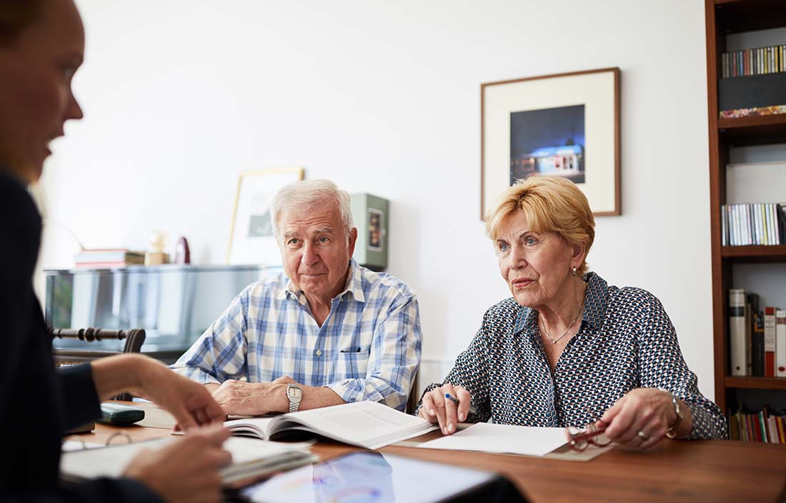 Older couple discussing finances with an advisor.