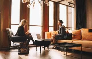 Two business professionals sitting in chairs having a discussion.