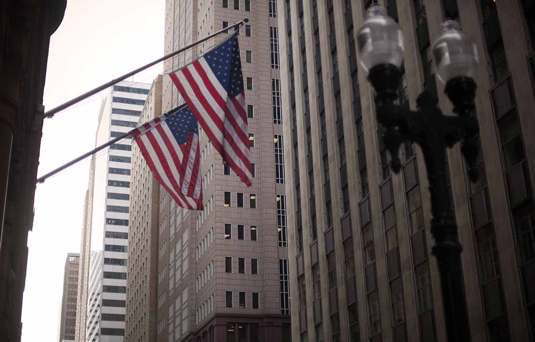 View of skyscrapers and flags in a city.