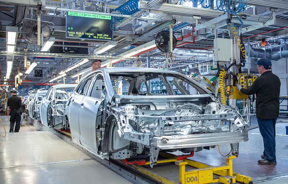 Factory workers assembling an electrical vehicle.