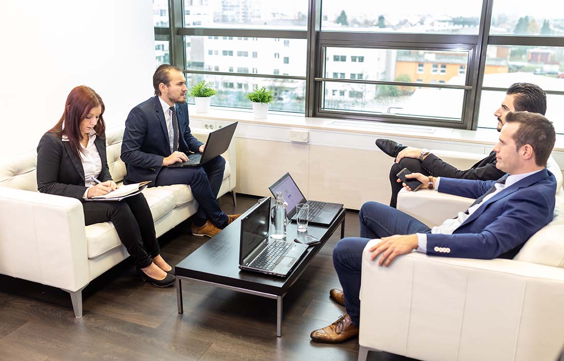 Coworkers talking and working in a modern conference room.