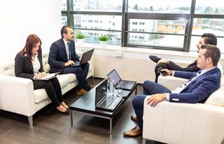 Coworkers talking and working in a modern conference room.
