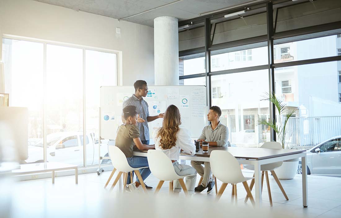 Group of business professionals discussing open enrollment in a modern conference room.