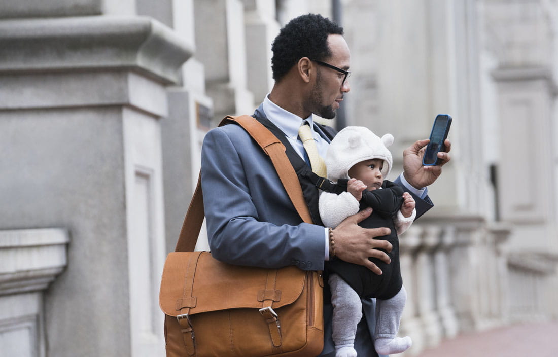 Business professional holding their baby and reading about state and local tax updates.