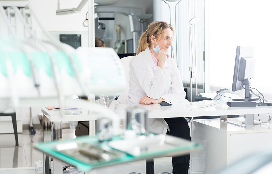 Doctor sitting at a desk using a computer