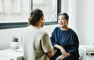 Two business professionals sitting down by a window discussing Michigan sales and use tax exemptions.