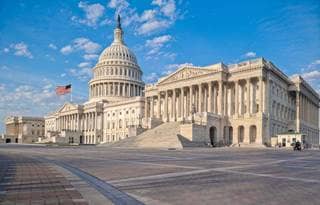 View of U.S. Congressional building against a blue sky.