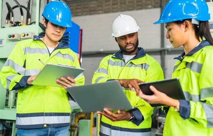 Construction workers in high-vis jackets discussing ERP.