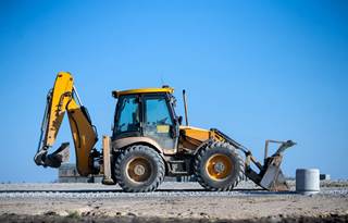 Excavator driving down a dirt road.