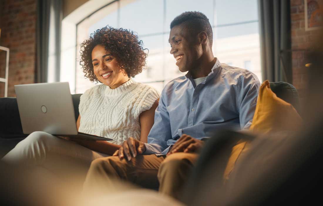 Couple reading an article on their laptop.