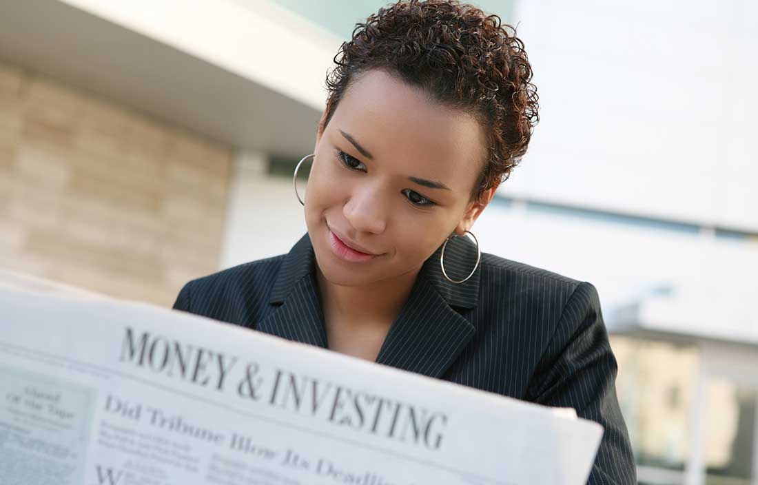 Financial advisor reading the "Money & Investing" section of the newspaper. 