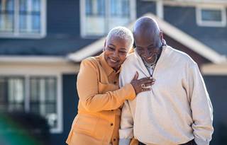 Older couple smiling and hugging each other.