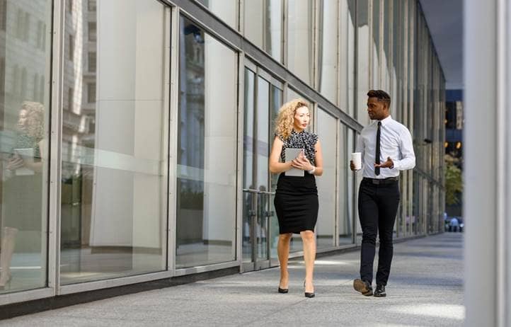 Two banking professionals walking and talking to each other.