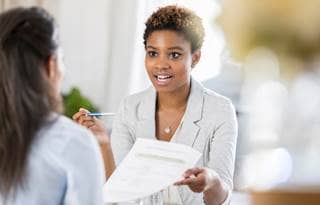 Business professional holding a pen and a piece of paper