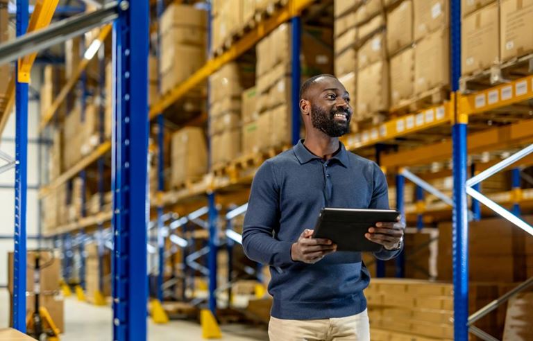 Supply chain specialist holding a clipboard in a warehouse