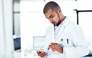 Doctor using a handheld tablet device