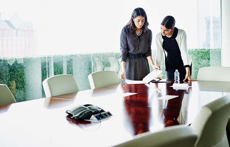 Two business professionals working in a conference room.