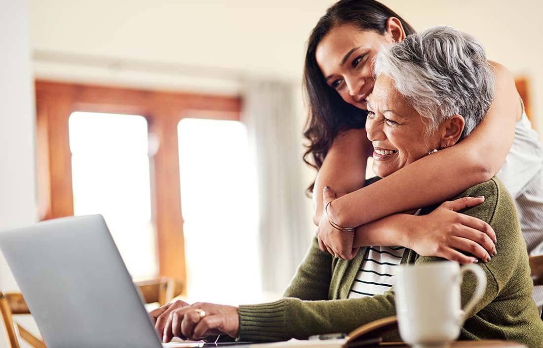 Mother and their adult child hugging.