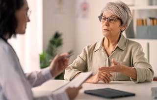 Catholic nun discussing potential Medicaid cuts with doctor.