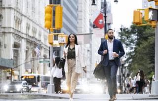 Two business professionals walking through a city's streets.