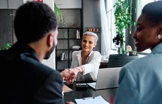 Benefit plan professional meeting with their clients and shaking hands.