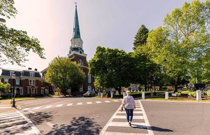 Person walking in a crosswalk to a church.