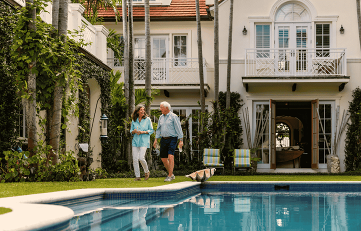 Senior couple walking alongside a pool.