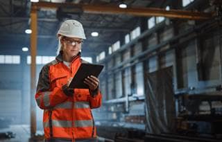 Manufacturing worker in a protective hardhat while in a warehouse