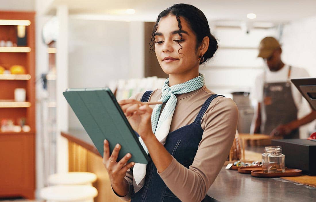 Restaurant owner reviewing information on their tablet.