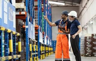 Two people talking in a factory.