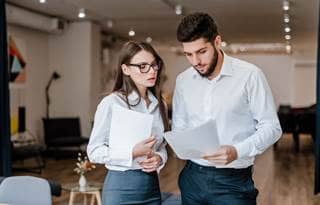 Two business professionals reviewing a document.