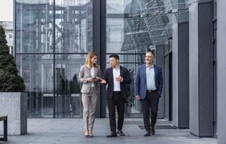 Employee benefits professionals walking outside of an office.