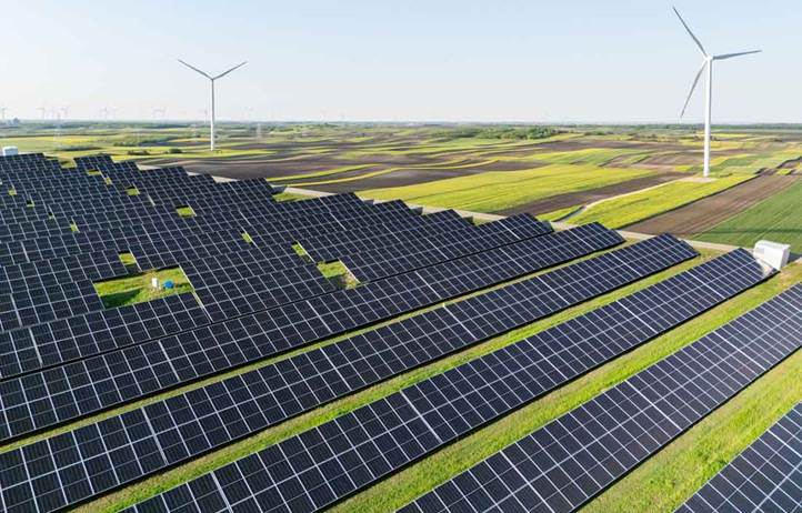 Field of solar panels and wind turbines.