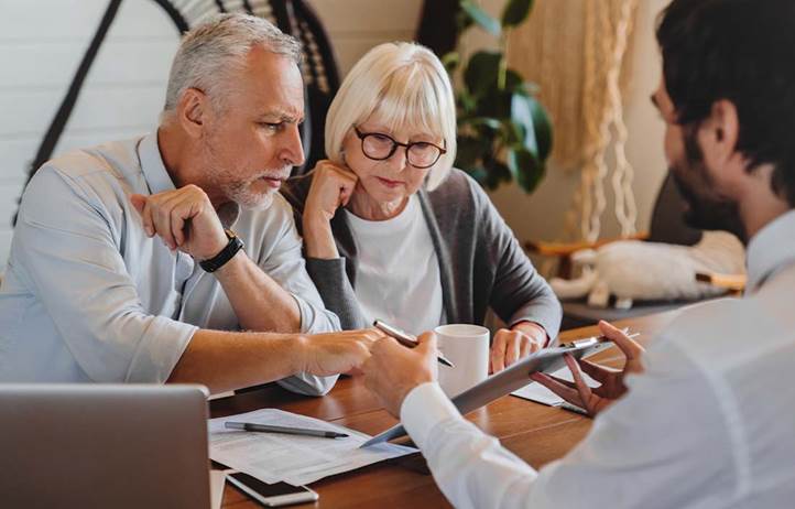Wealthy couple talking to their financial advisor.