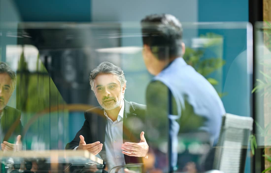 Business professionals having a conversation in a modern office.
