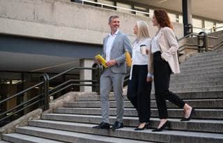 Two business professionals walking down stairs.