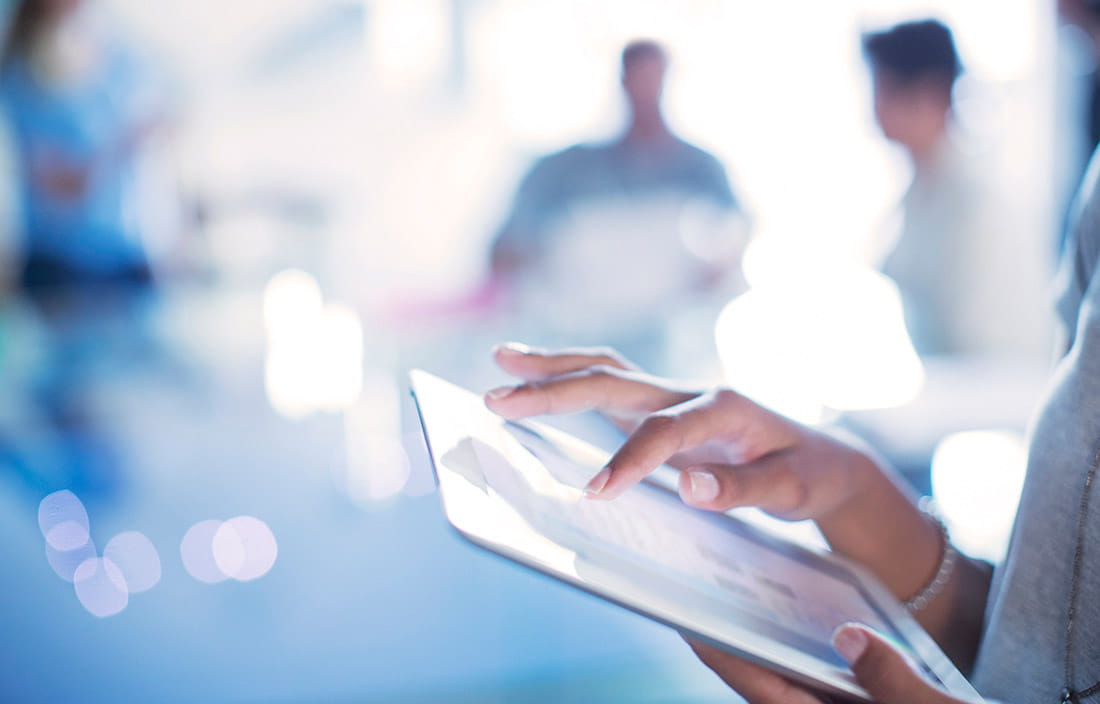 Close up of a woman's hands scrolling through an iPad