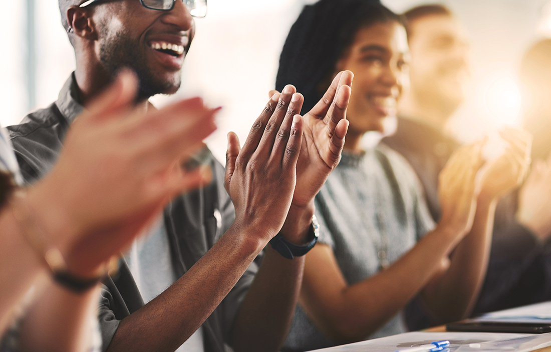 Up close shot on multiple people smiling and clapping their hands