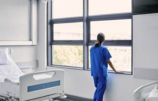 A nurse standing against a window