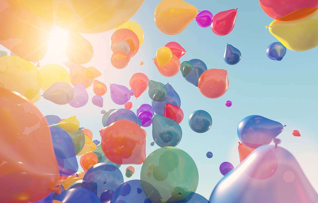 Balloons flying through a sunny sky