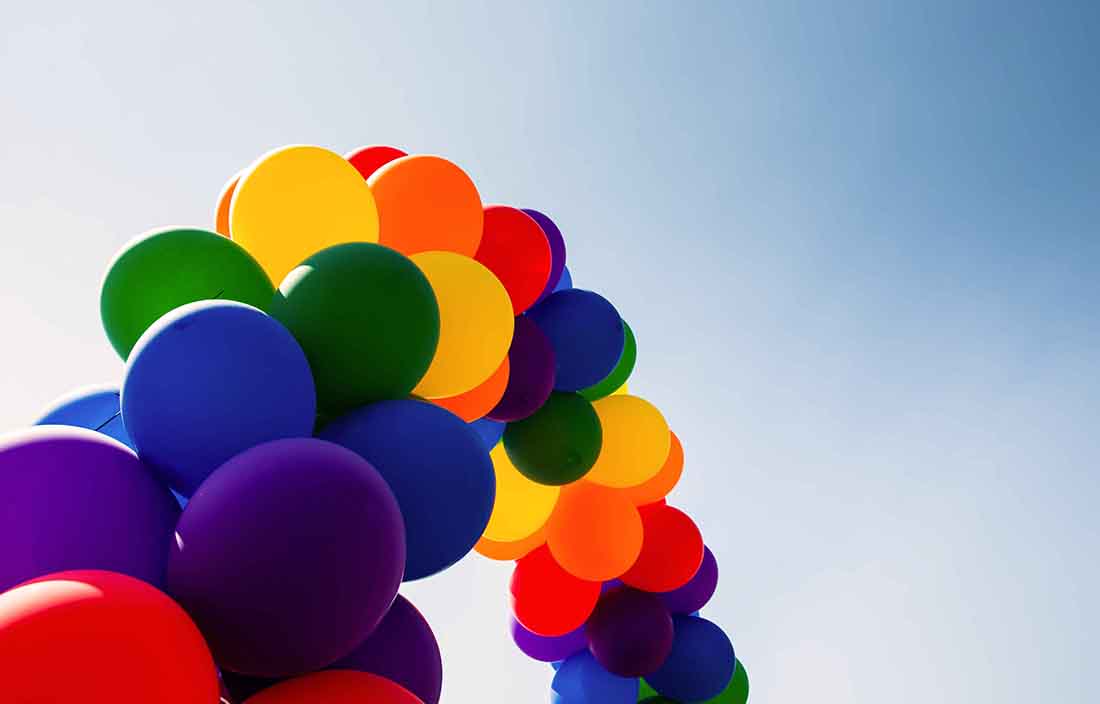Multi-colored balloons on a rope in the shape of a rainbow