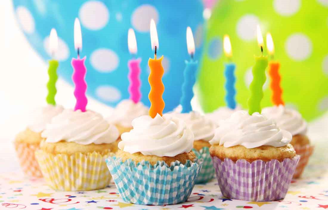 Close-up view of cupcakes with candles in them.