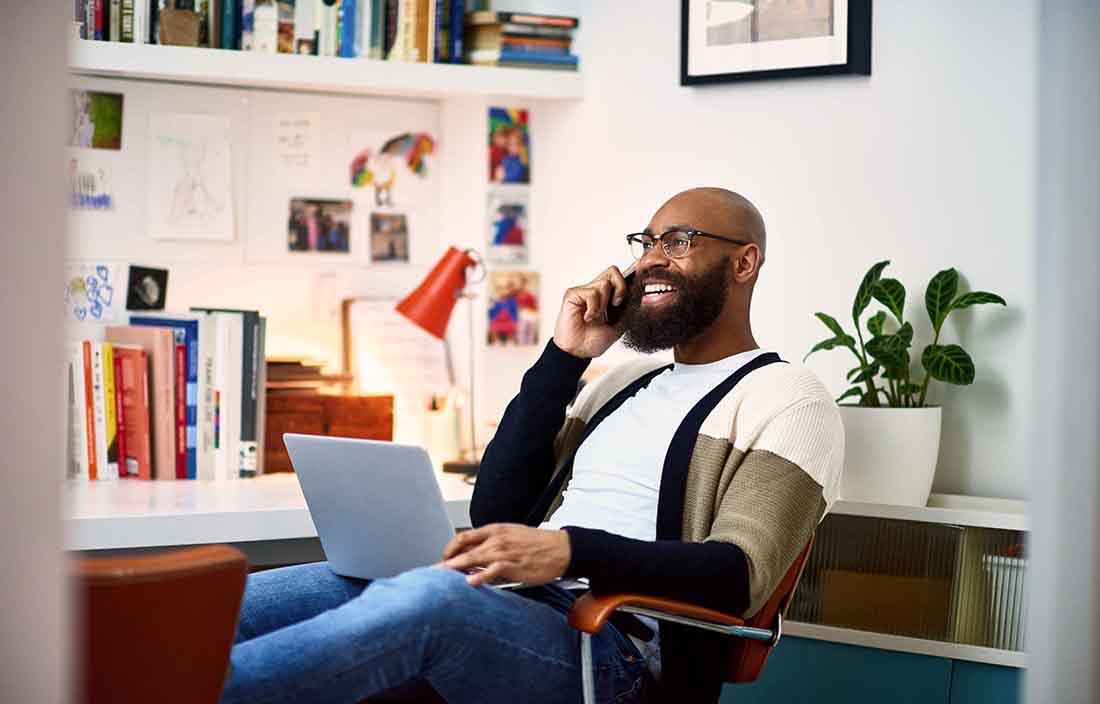 Business professional in casual clothes taking a call from their home office.