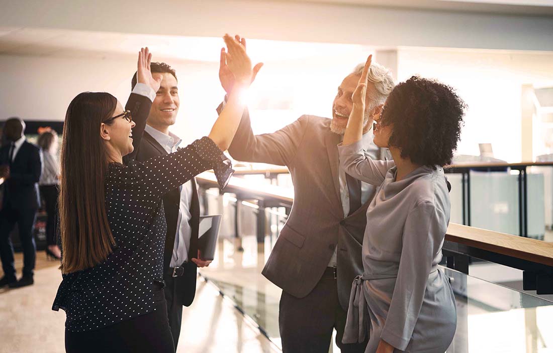 People celebrating and giving each other high-fives.