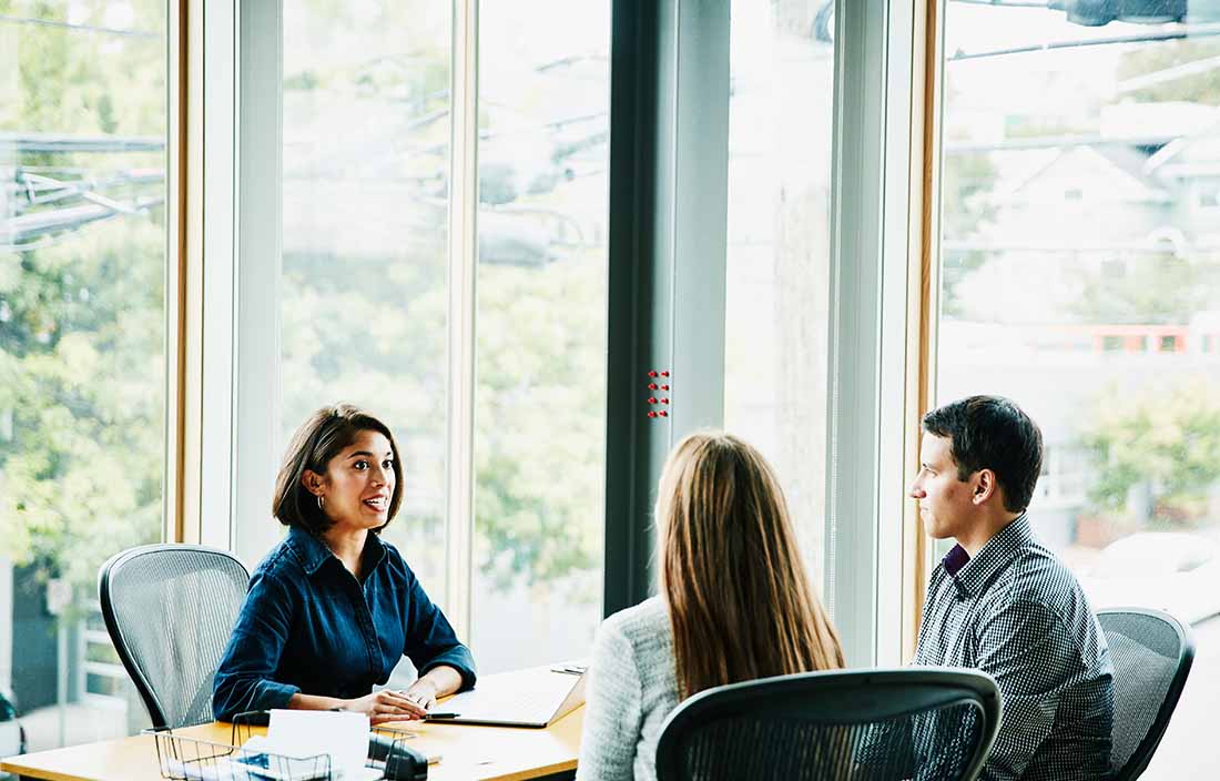 Business professional in a modern office discussing retirement tips with clients.