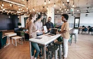 Group of business professionals chatting in a modern office.