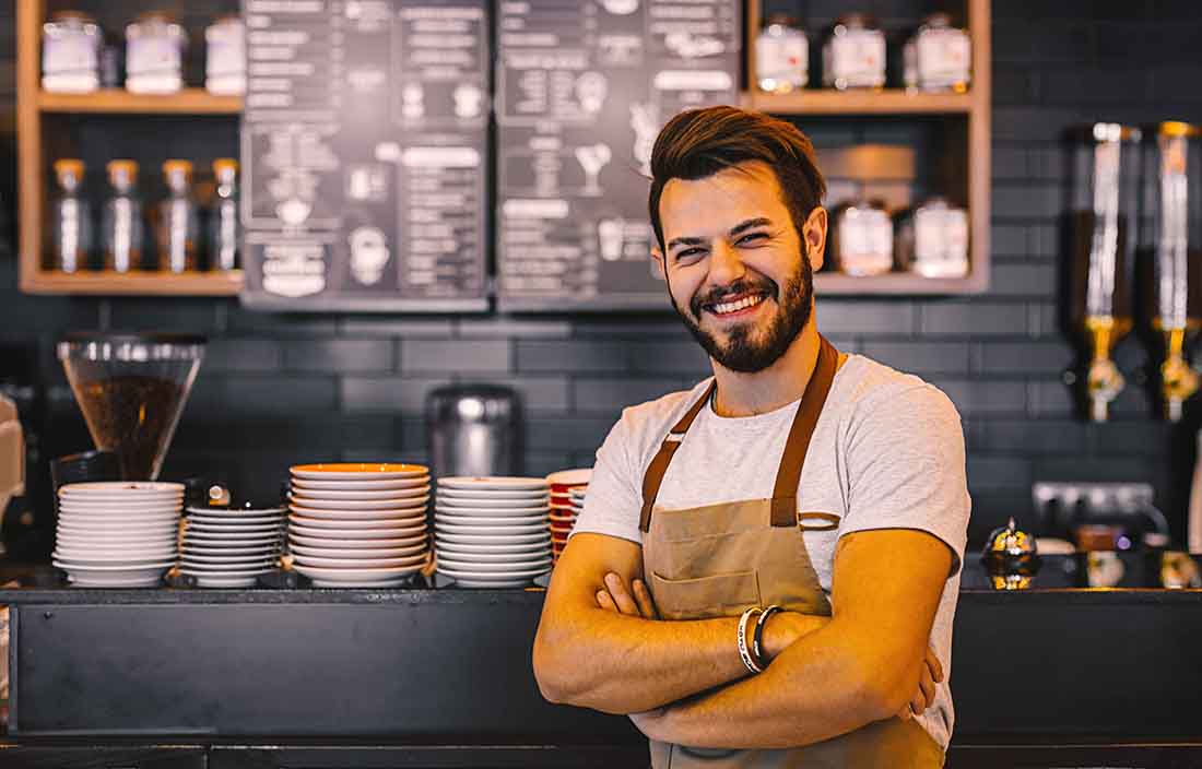 Smiling man standing in café.