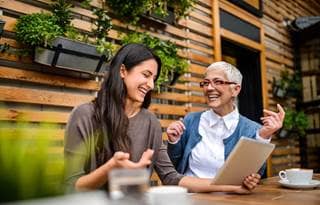 Two business professionals sitting at a table laughing and smiling