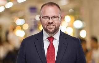 Professional photo of Bradley Bryant in front of a brightly colored background.